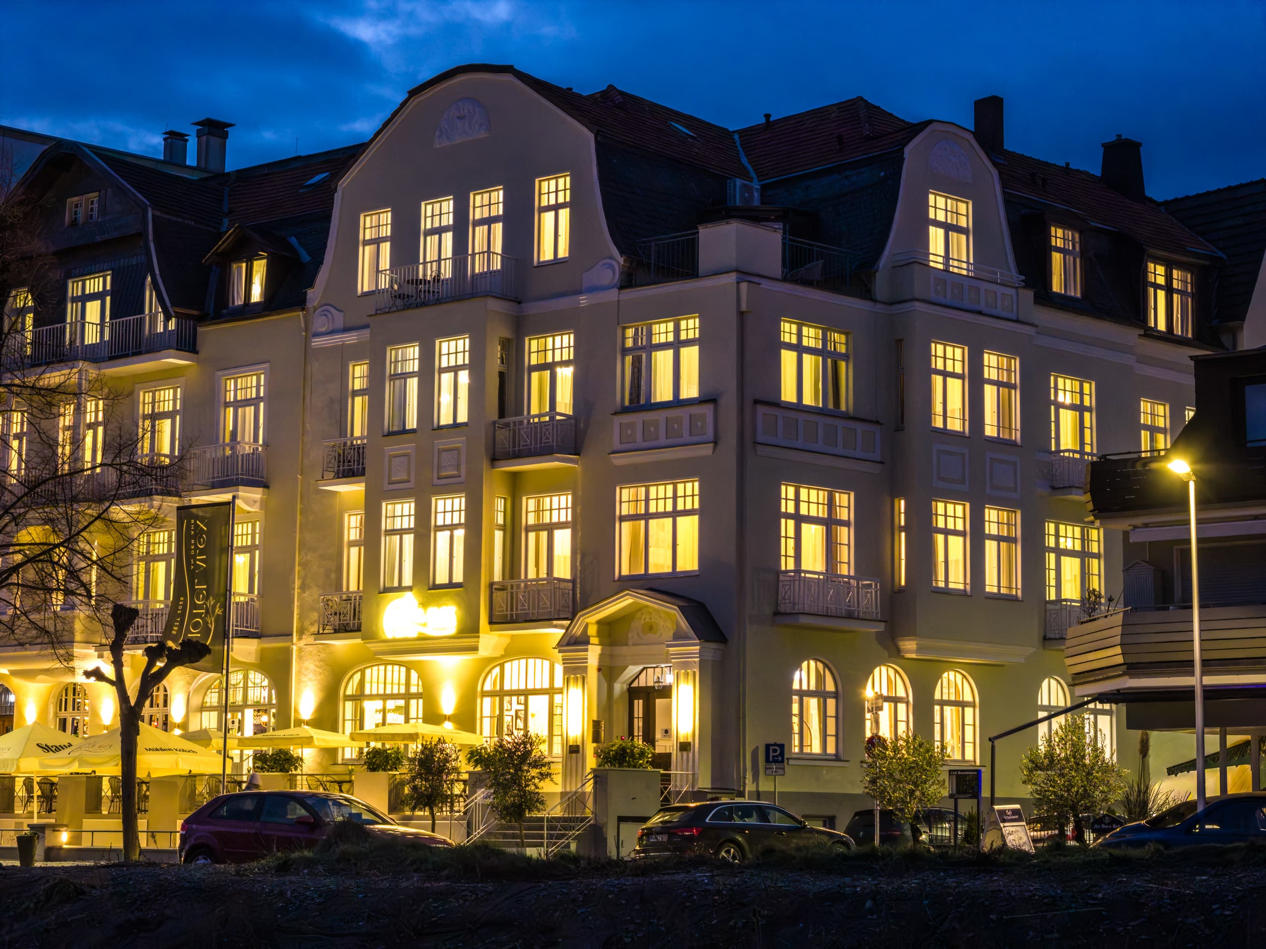 Die beleuchtete Jugendstilfassade des Hotel Alex am Abend