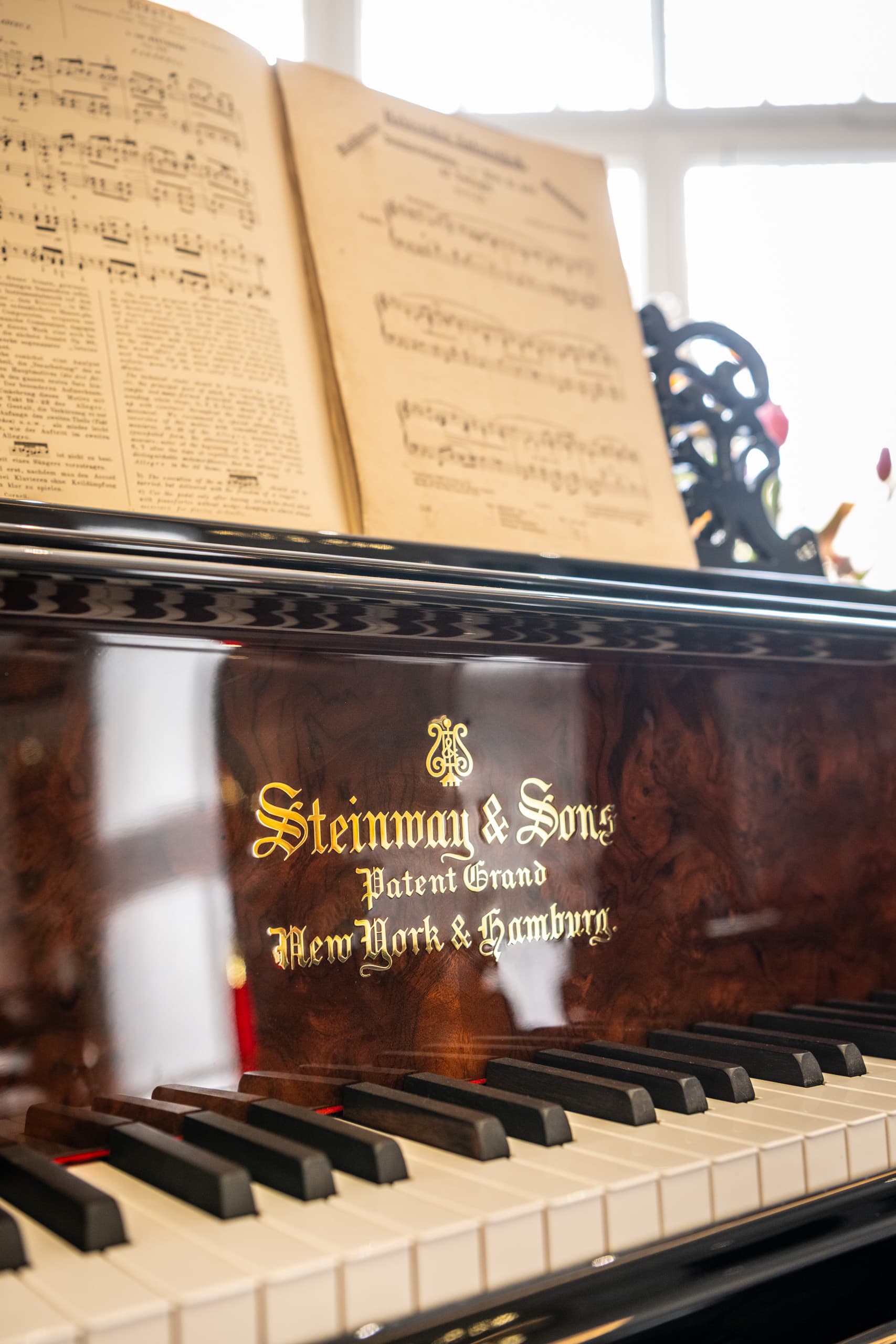 Steinway-Flügel im Detail mit Klaviertasten und aufgeschlagenen Noten