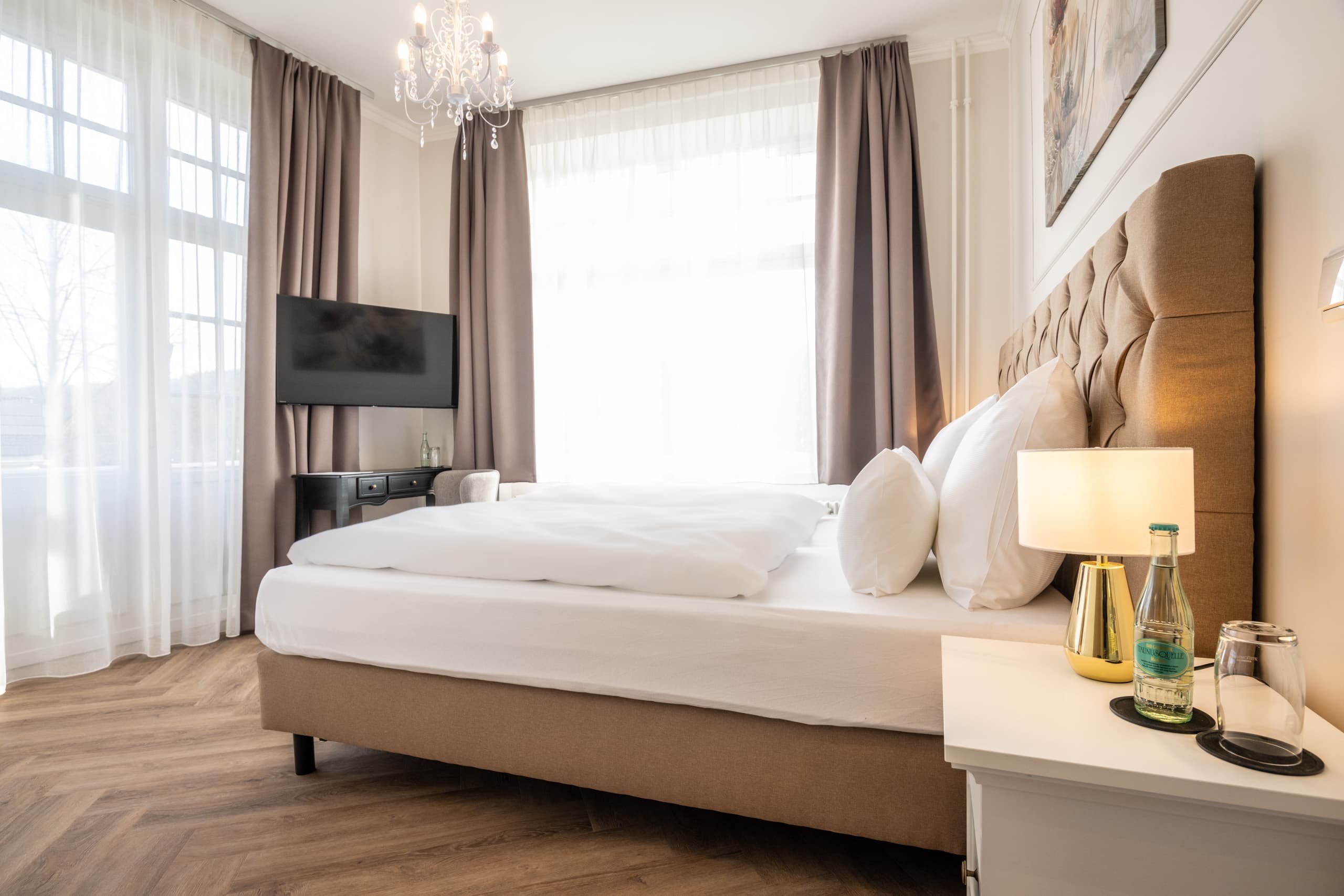 Standard Doppelzimmer mit großen Fenstern und gepolstertem Doppelbett