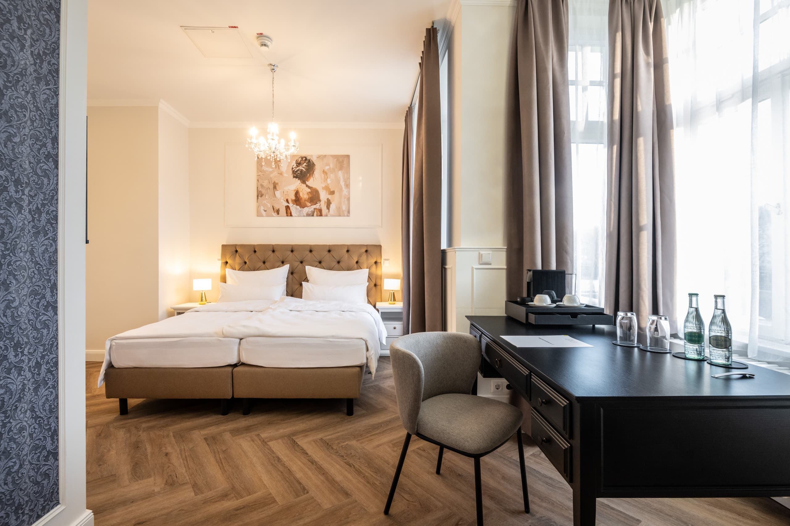 Junior Suite mit Doppelbett, Schreibtisch und großen Fenstern
